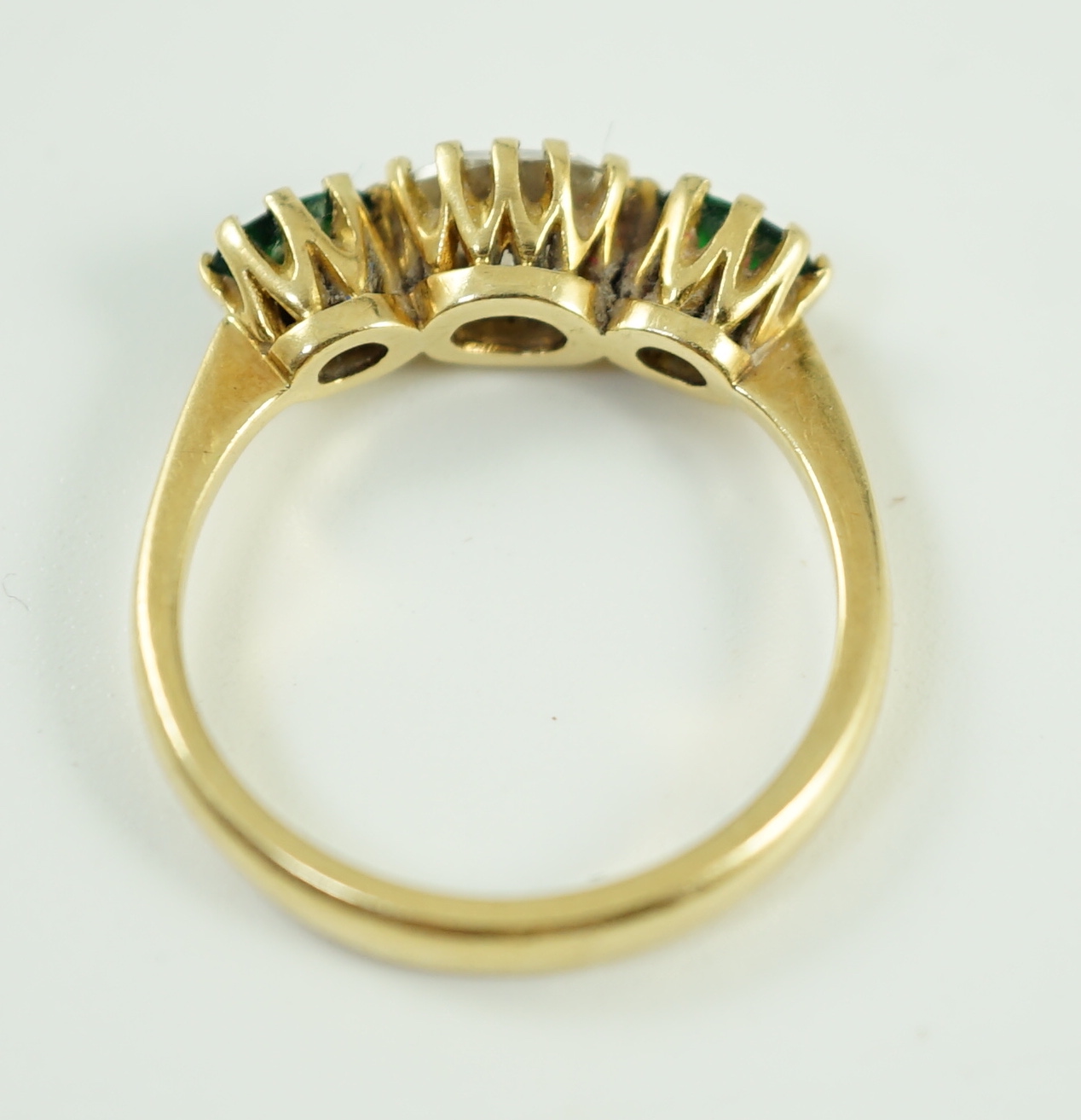 A modern 18ct gold, diamond and green tourmaline set three stone ring